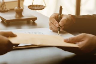 © Wicitr - stock.adobe.com Foto: Person unterschreibt Dokument