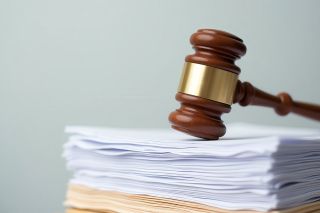© johndaly - stock.adobe.com Foto: Richterhammer liegt auf Stapel Dokumente